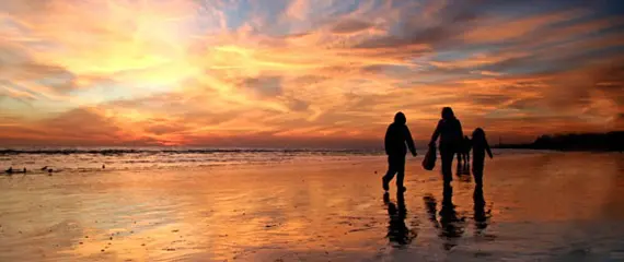Two people on the Rhyl beach at sunset