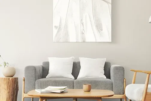 Home furniture featuring a grey sofa with white cushions